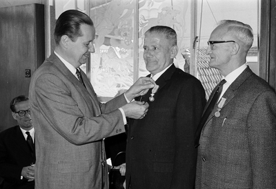 128871 Afbeelding van de uitreiking van een ere-medaille aan de heren J.P. Koppe (midden) en J. Spaan (rechts) uit ...
